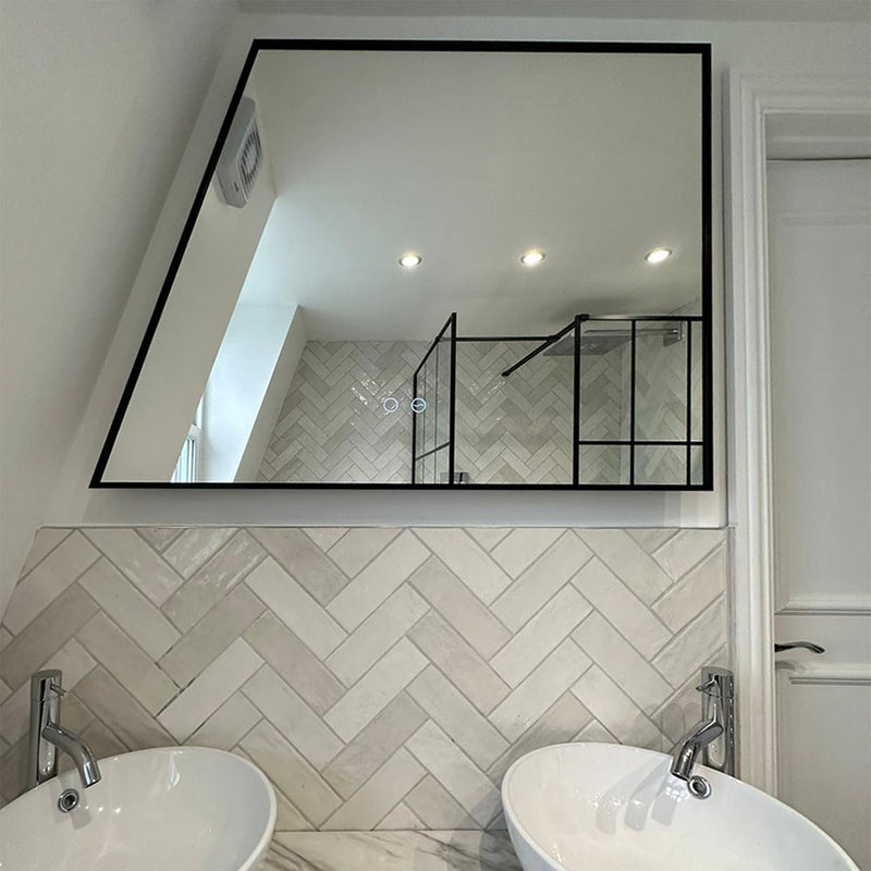 Backlit trapezium-shaped mirror with touch sensor controls and black metal frame