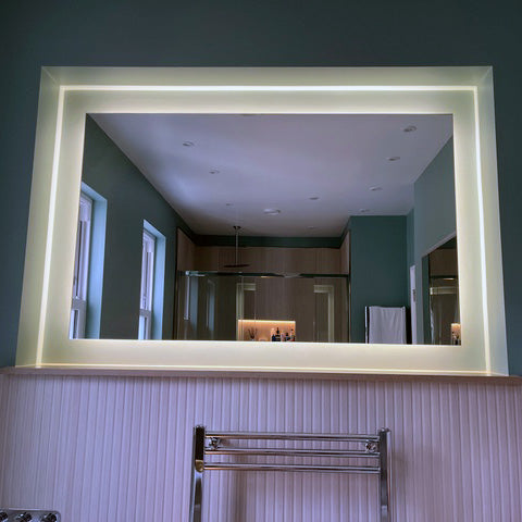 Backlit mirror perfectly illuminates this bathroom alcove