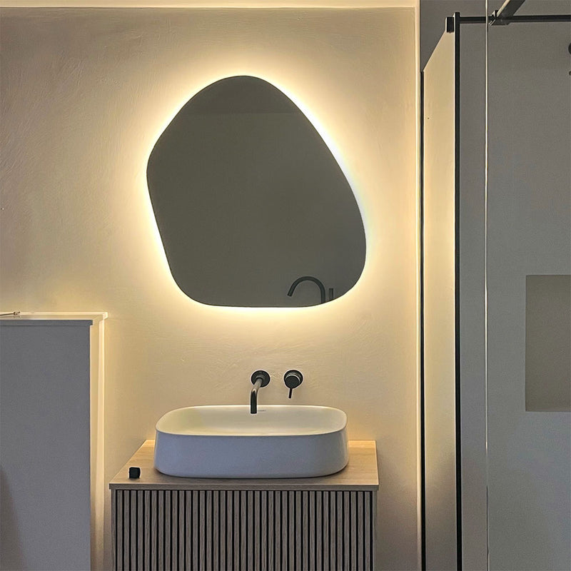 Asymmetrical backlit mirror