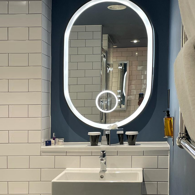 Exquisite pill-shaped bathroom mirror with metal frame for Malmaison Hotels