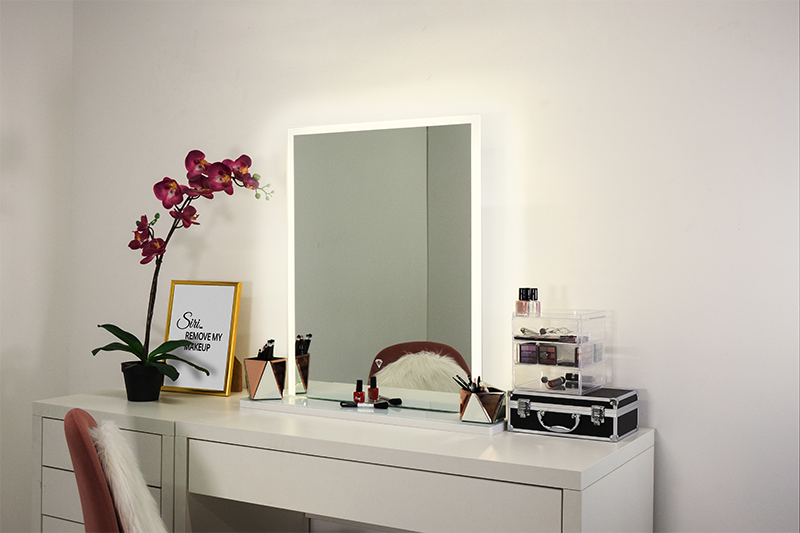 A beautifully modern bedroom vanity mirror, edge-lit & with a white glass base